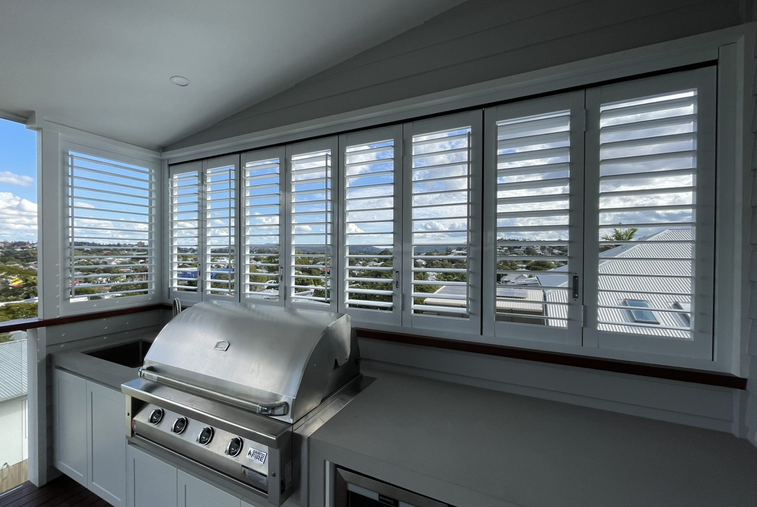 Aluminium bi-fold shutters folded open on a home exterior