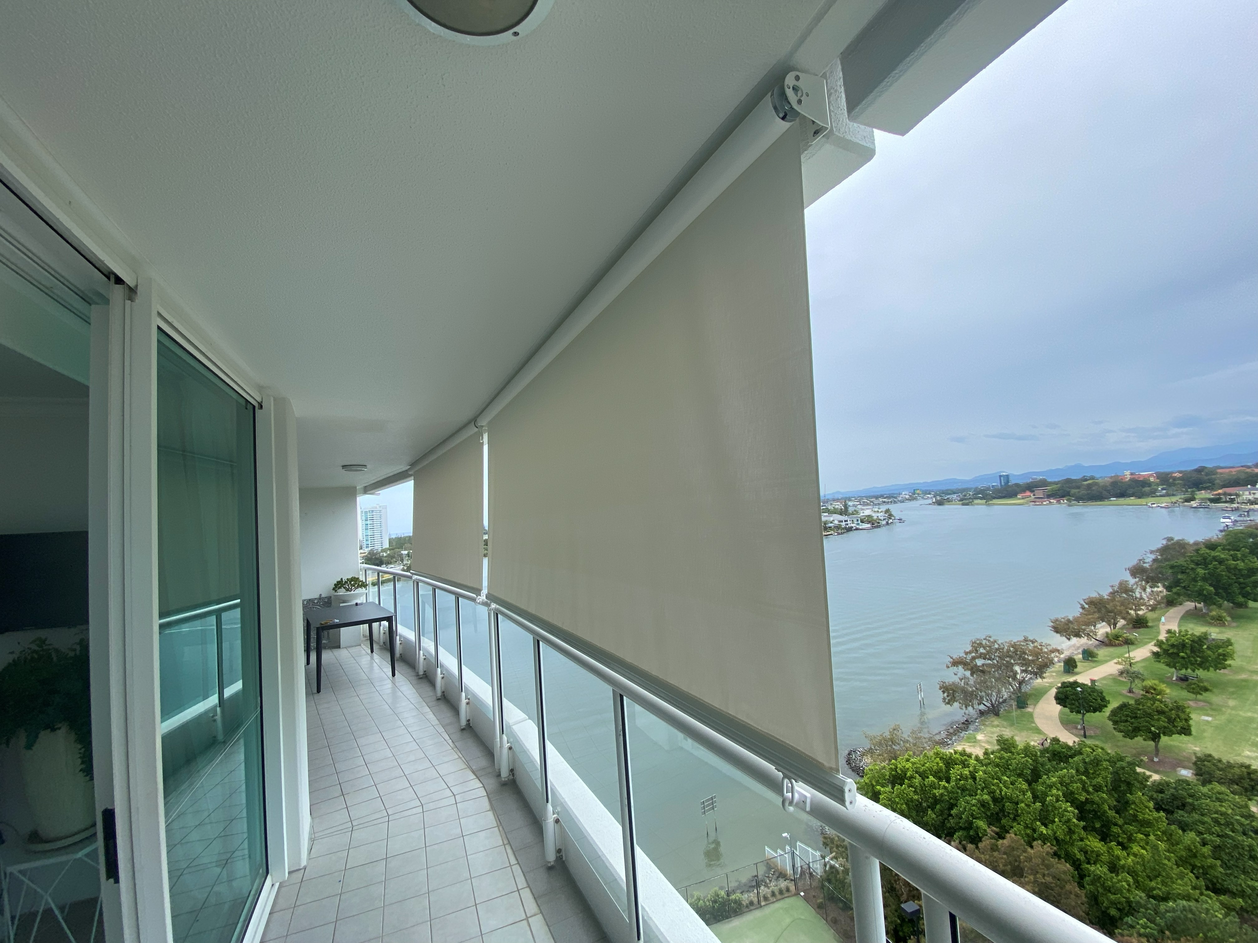 Crank operated outdoor blind lowered on a high-rise balcony overlooking the river