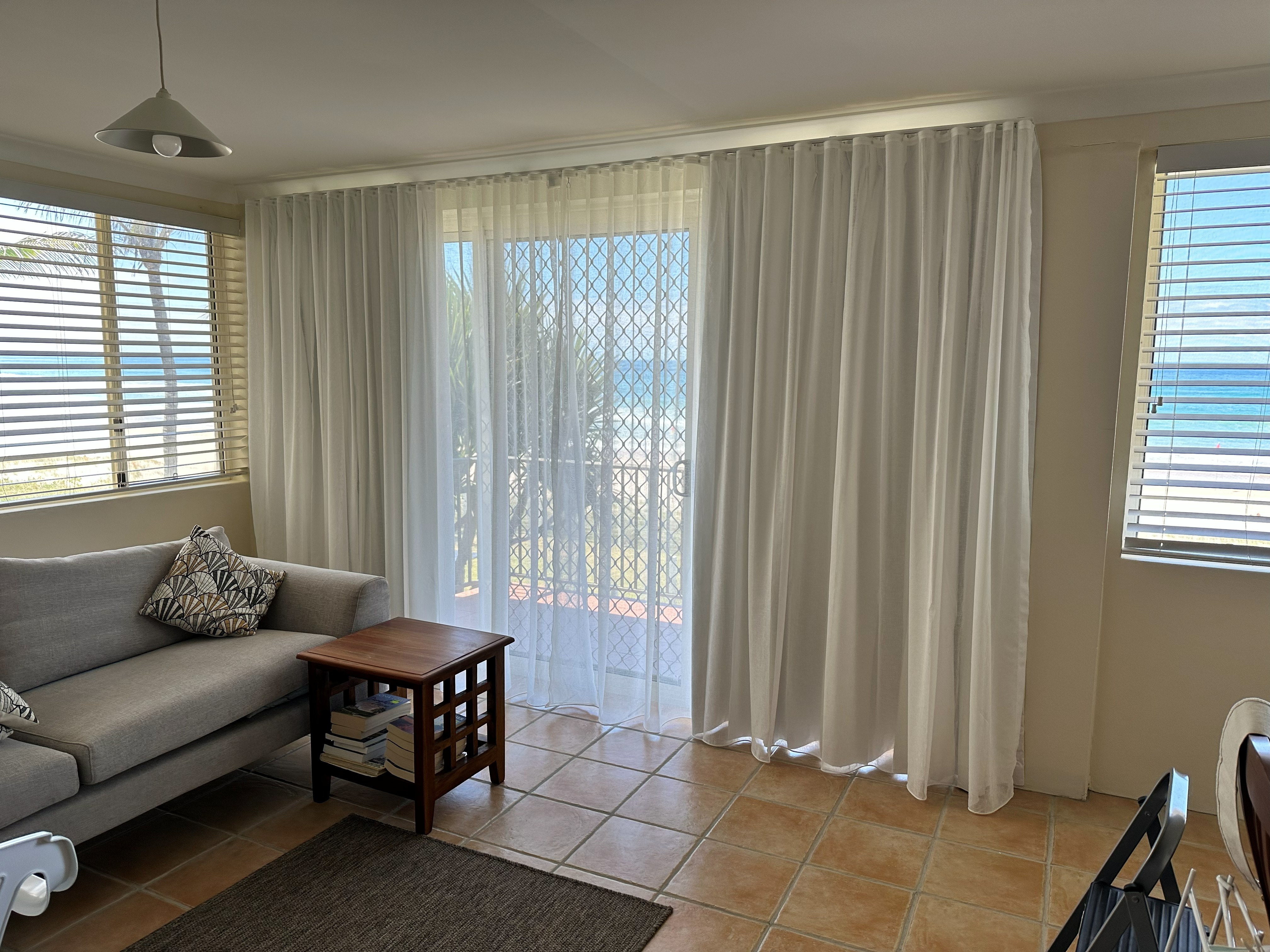 Double track curtains with sheer and blockout layers over a beachfront sliding door