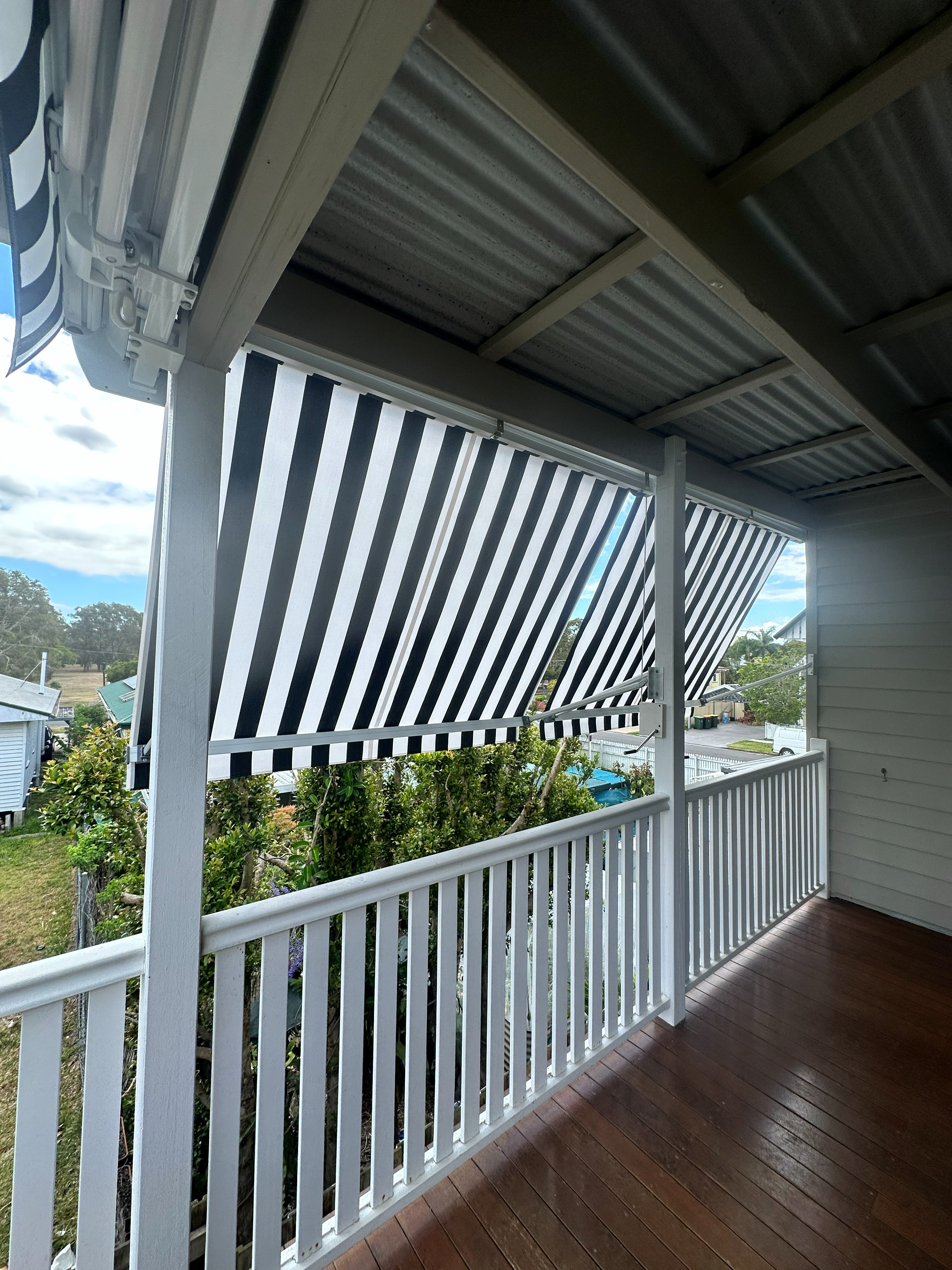 Striped drop arm awnings extended along a covered verandah
