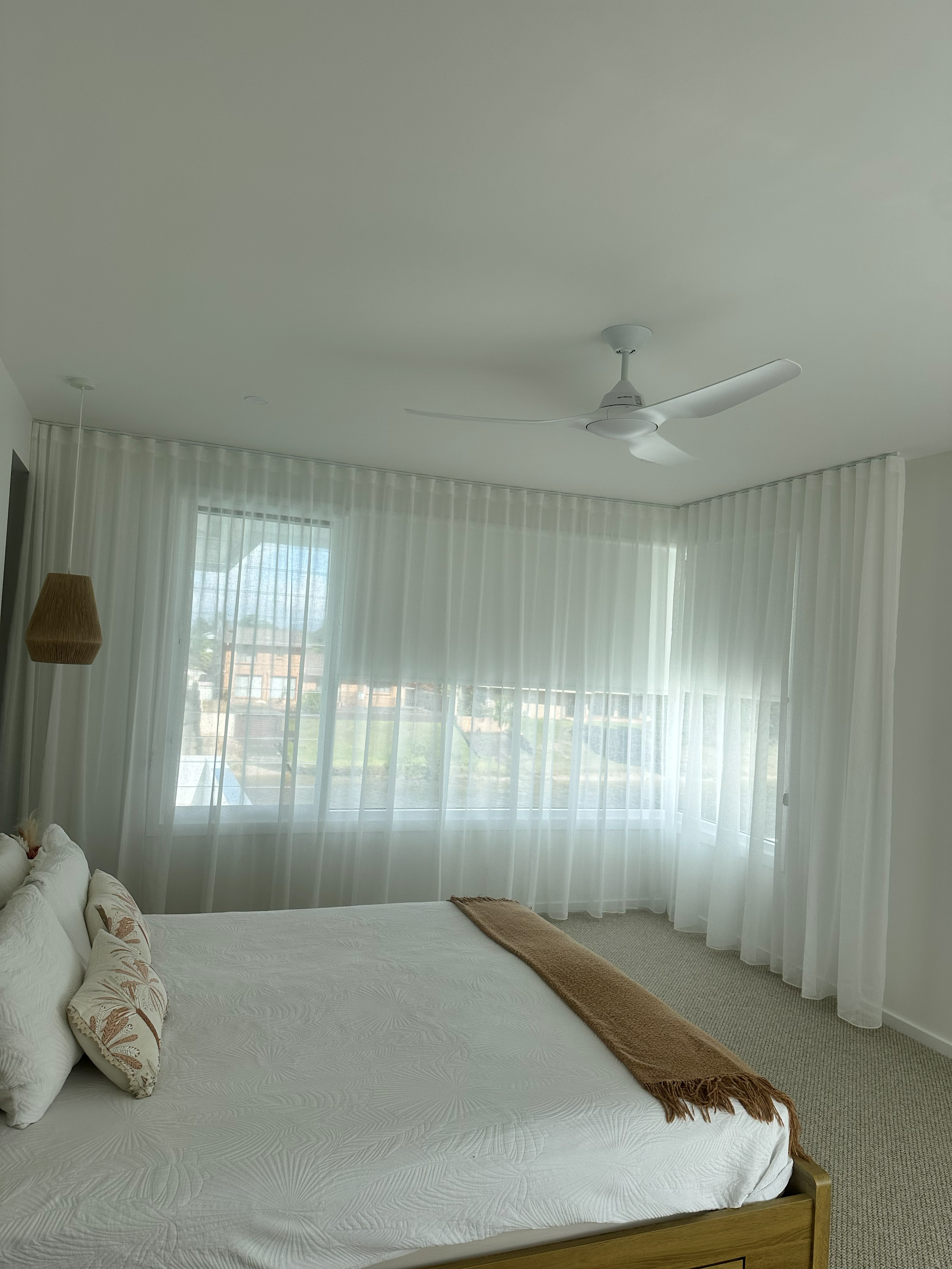 Sheer curtains in a bedroom overlooking a waterfront view
