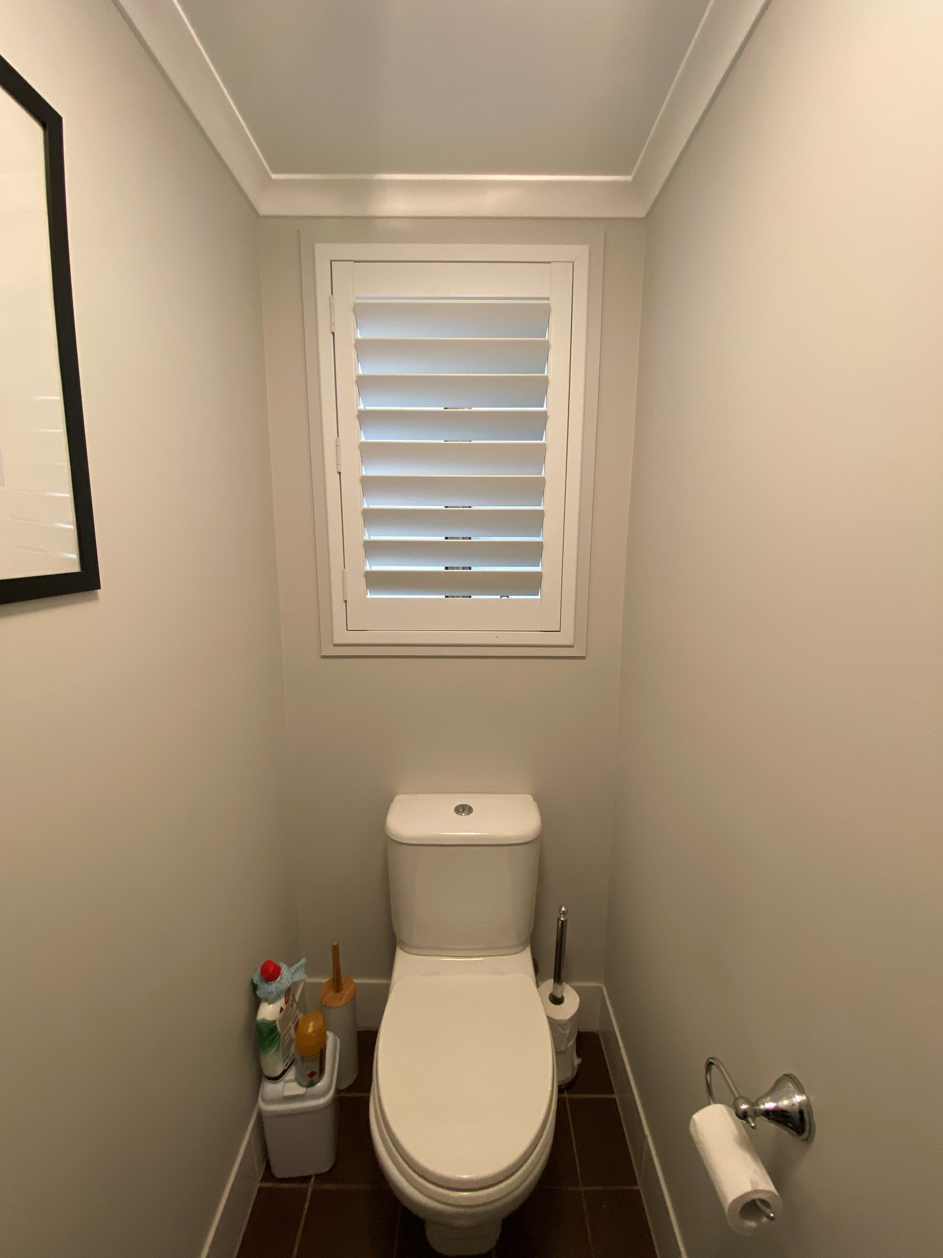 Plantation shutter fitted above a toilet in a small powder room