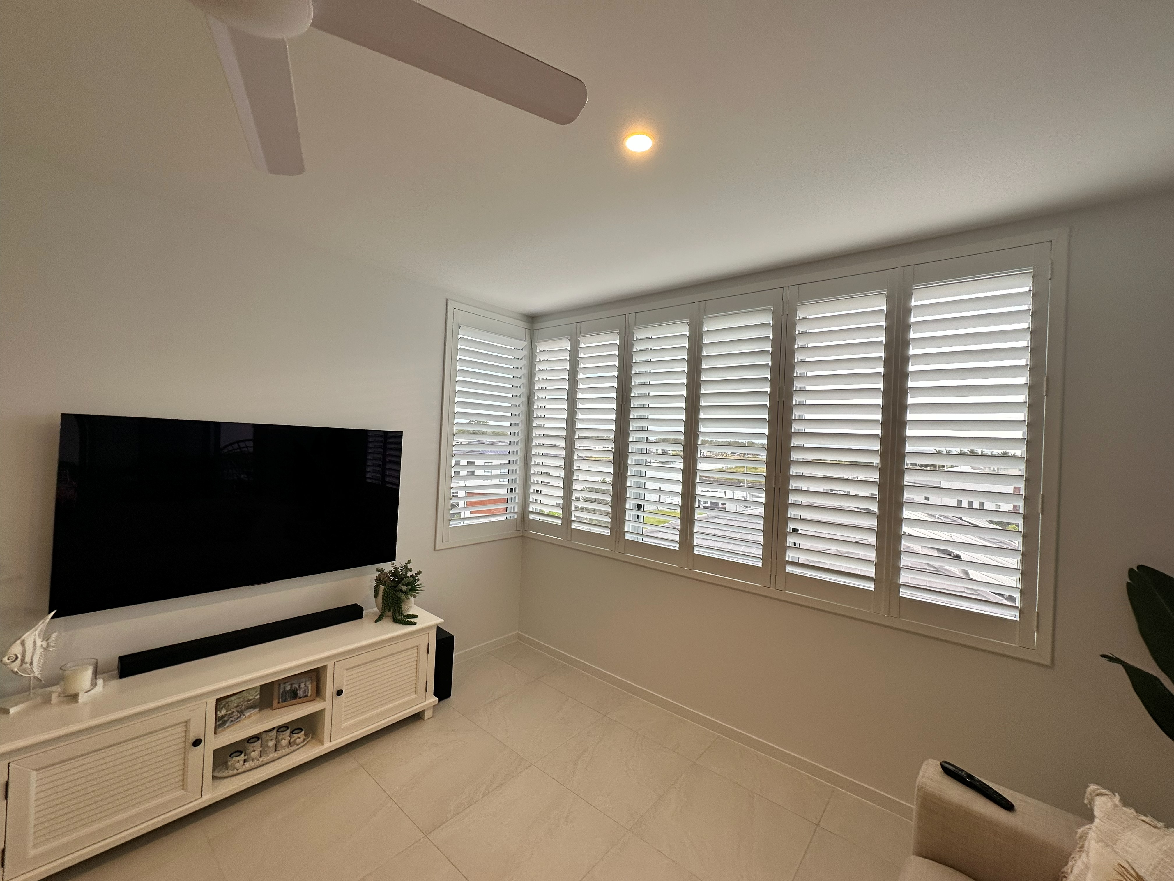 Plantation shutters in a living room overlooking an apartment complex