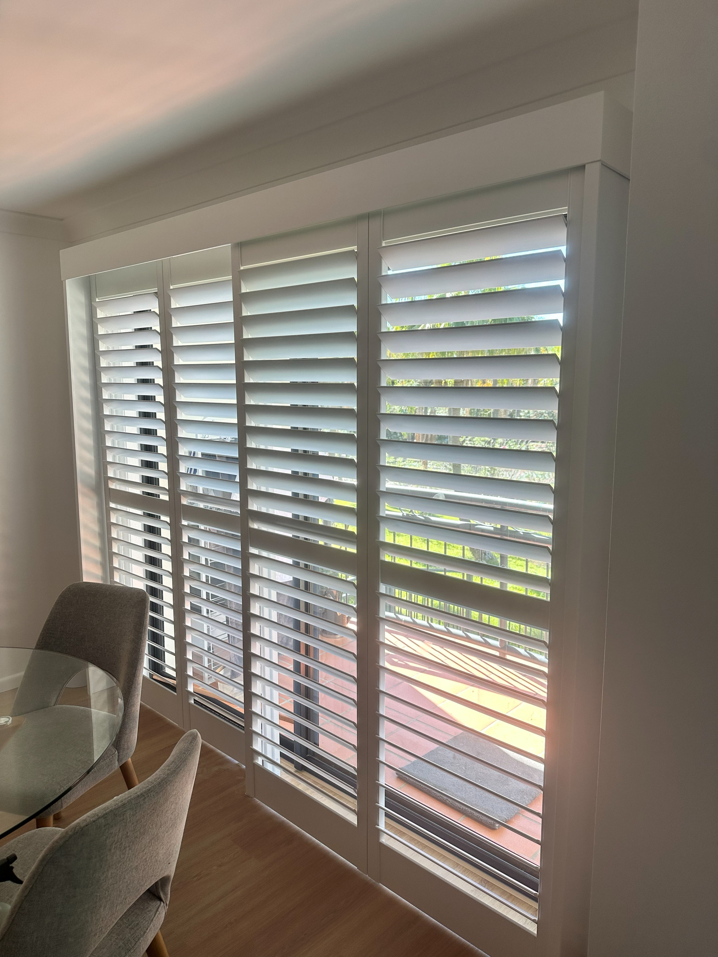 Sliding shutters over a dining room door with view to a balcony