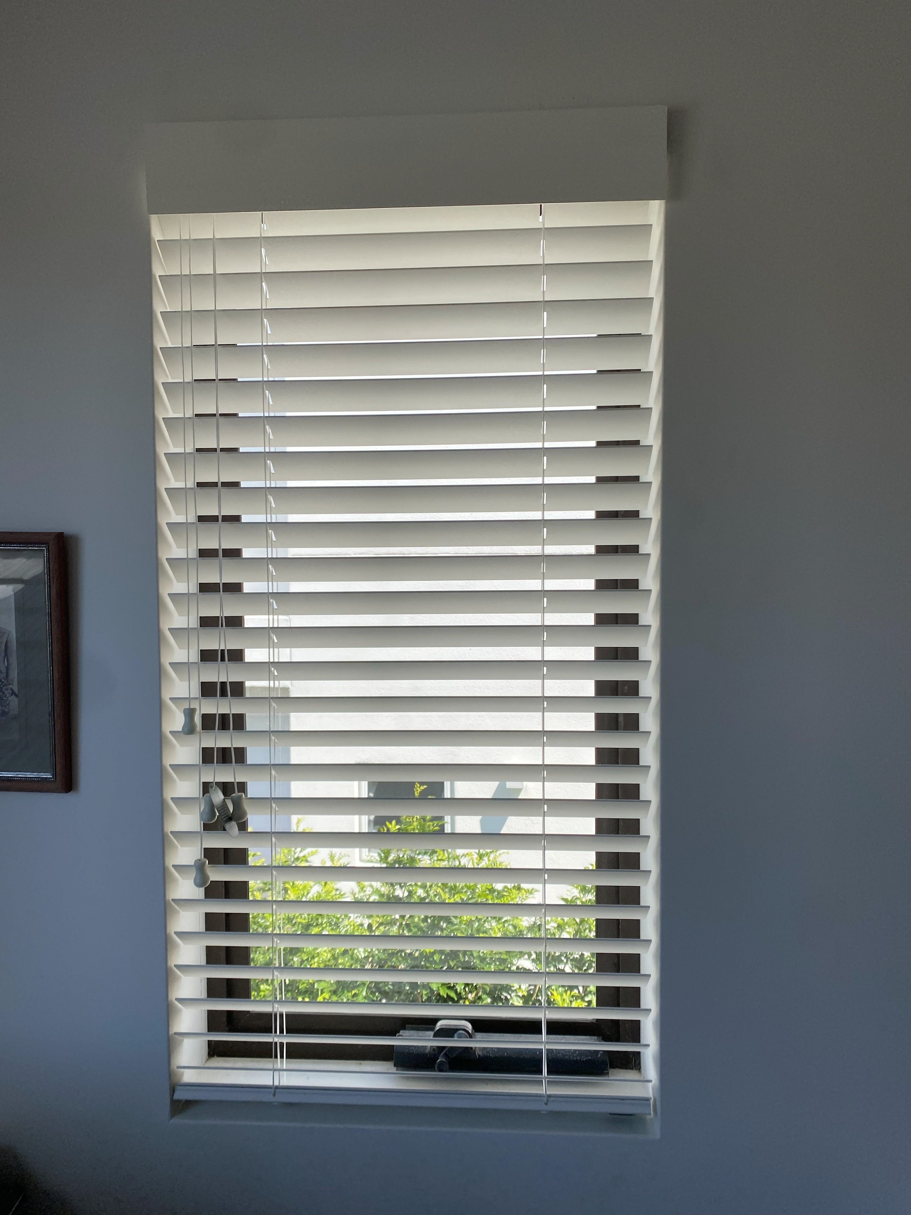 Close-up of white venetian blind slats fitted to a tall window