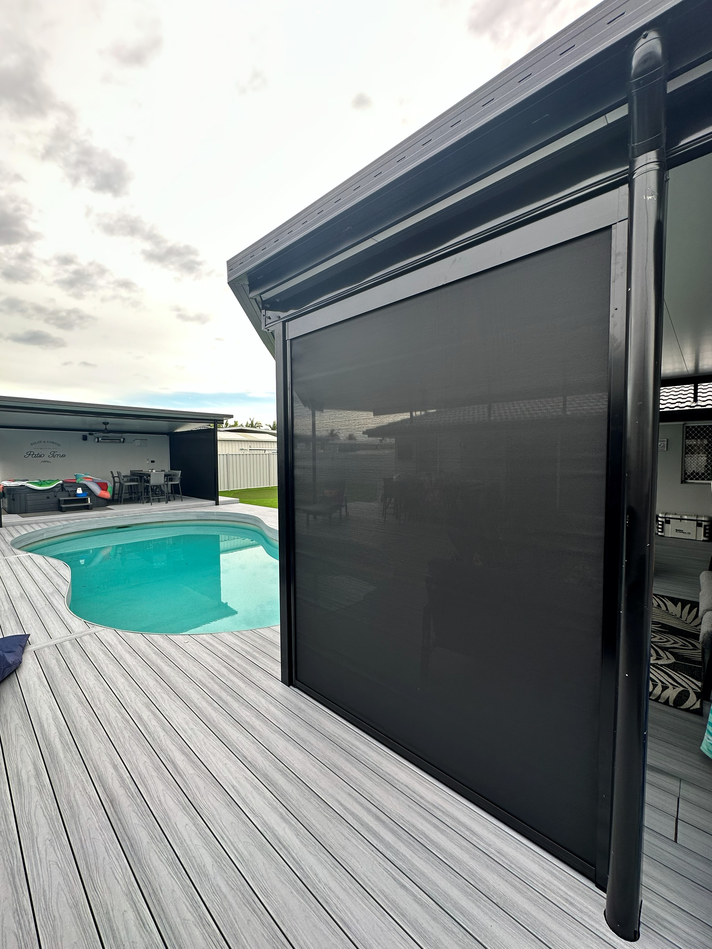 Zipscreen outdoor blind fully lowered beside a pool deck